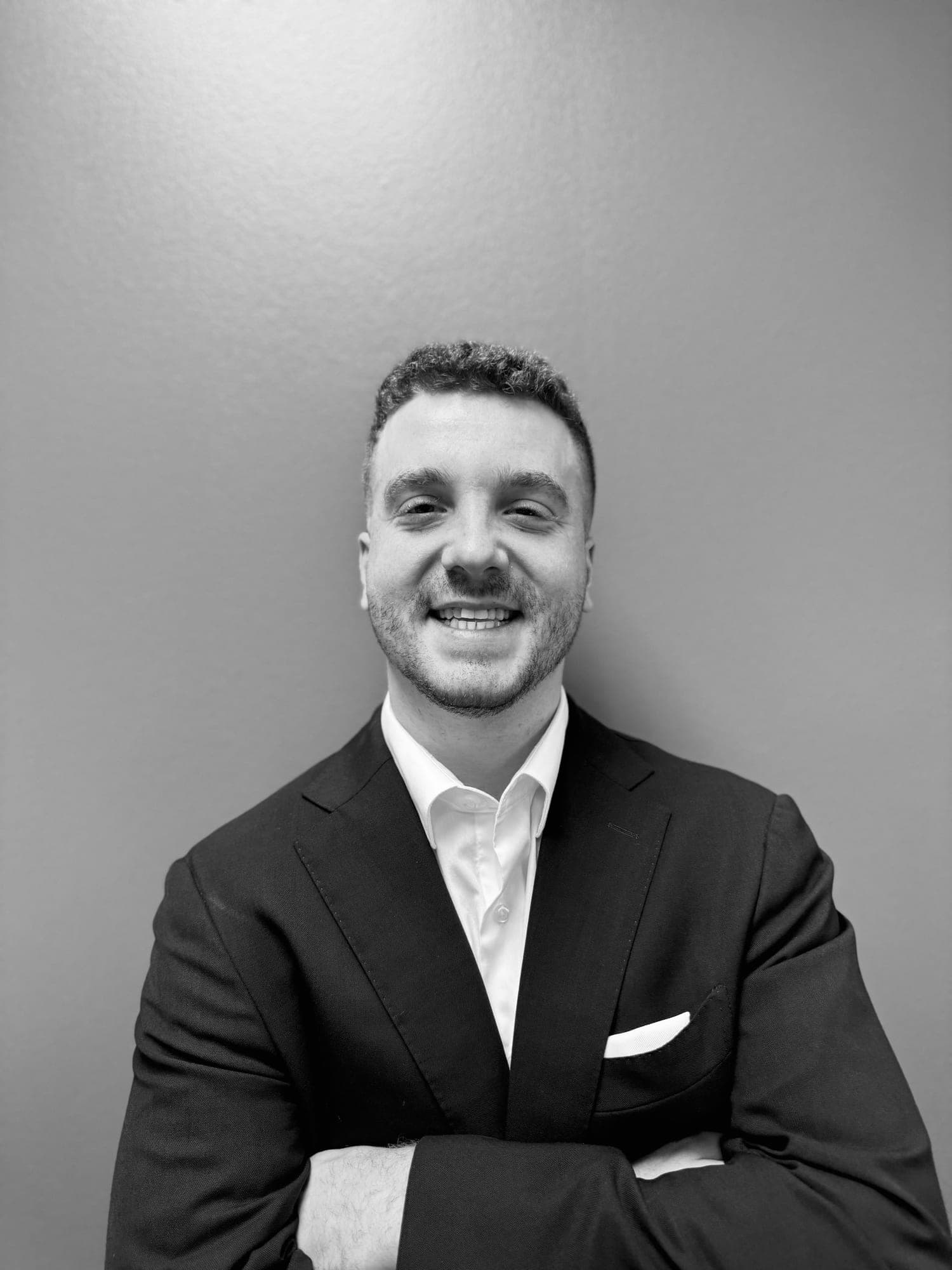 Matthew Schulster, black-and-white portrait with arms crossed